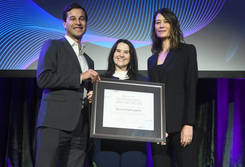 2024 Entertainment Law Initiative Writing Contest winner Olivia Fortunato (center) receives her scholarship award from ELI Executive Committee member Stephanie Yu and 2023 winner Aron Lichtschein